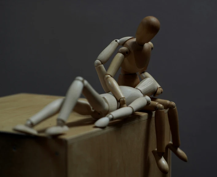 an animated wooden figurine sitting on top of a piece of wood