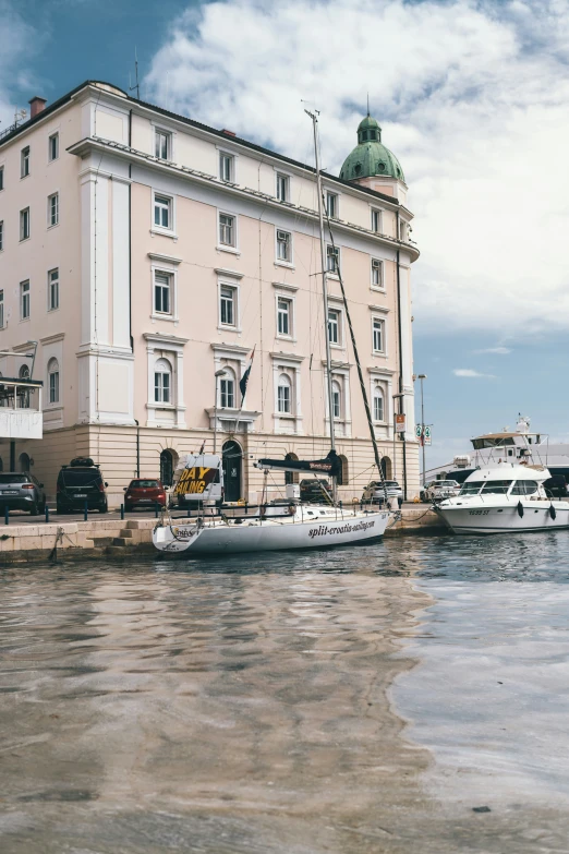 some boats are docked next to a very large building