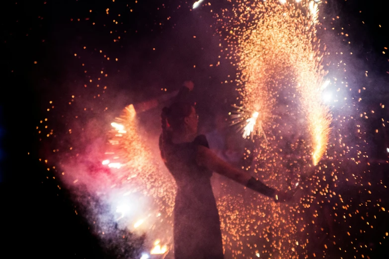 a boy holding his arms in front of fireworks