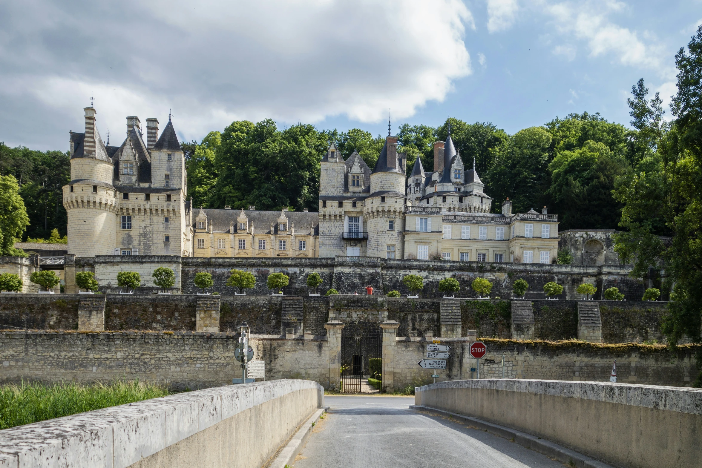 a castle with a street next to it near trees