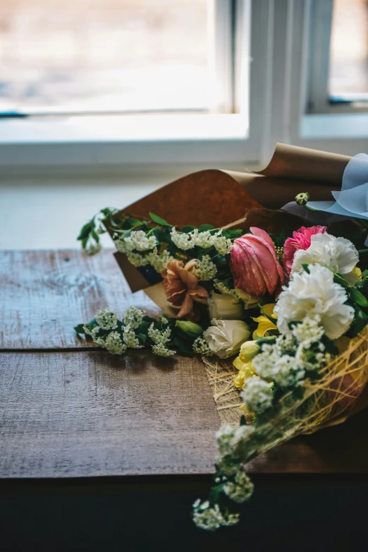 the flowers are on the table near the window