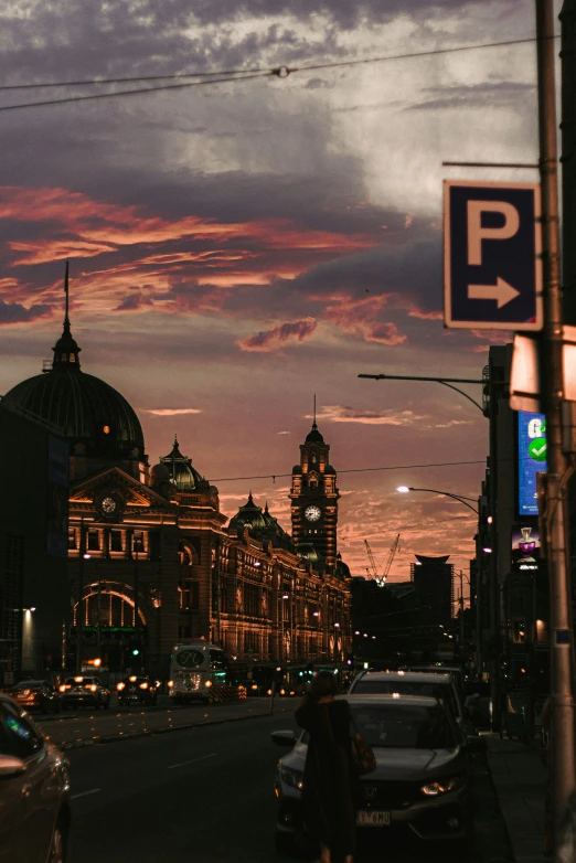 dusk in a european city, as cars drive by