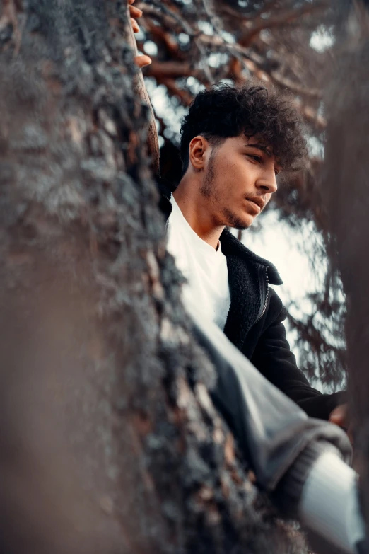 a man looks back while standing in the woods