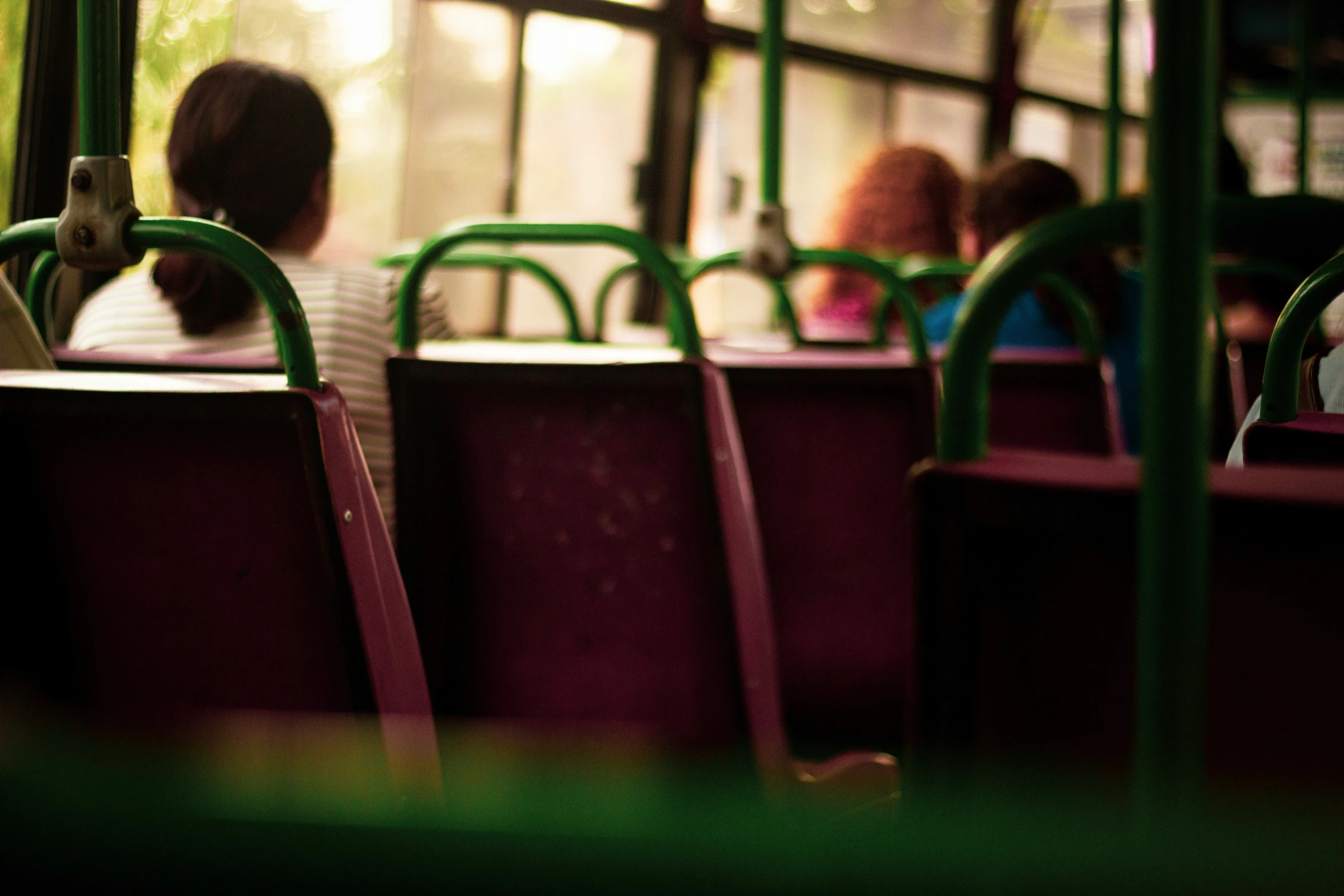 people ride on the bus while the seat cover is red