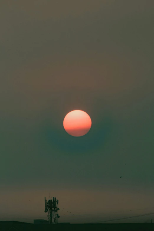 a red sun shines in the evening sky