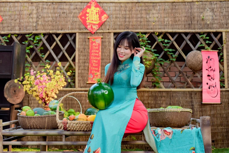 a beautiful woman sitting on a table with fruits in front of a building