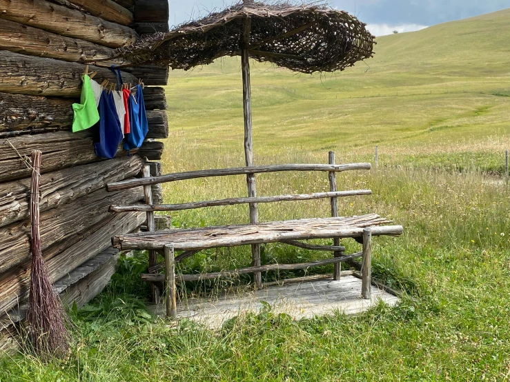 there is a bench next to a log cabin