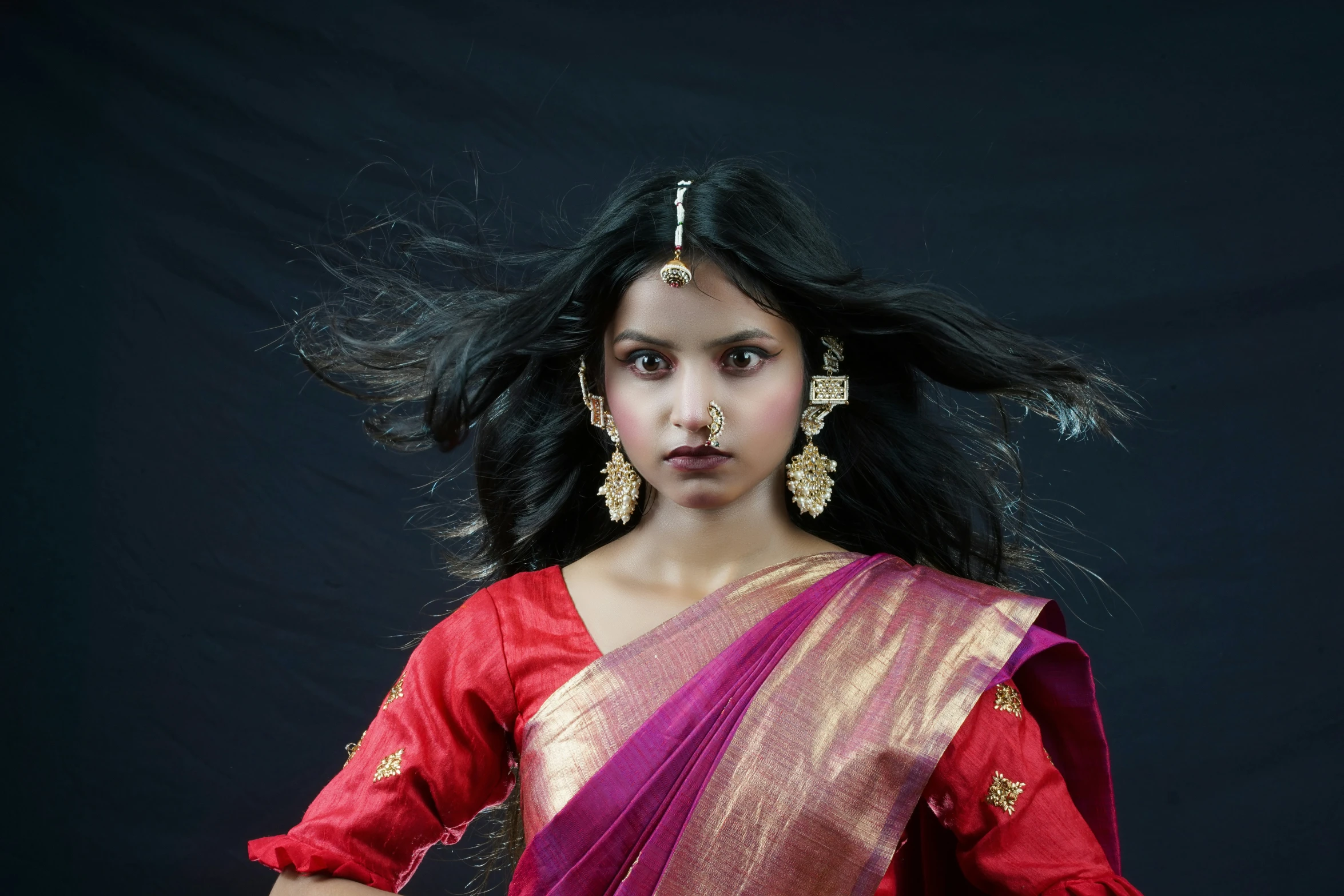 a woman in a pink and pink sari with a black background