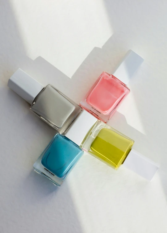 three nail polish bottles on a white surface