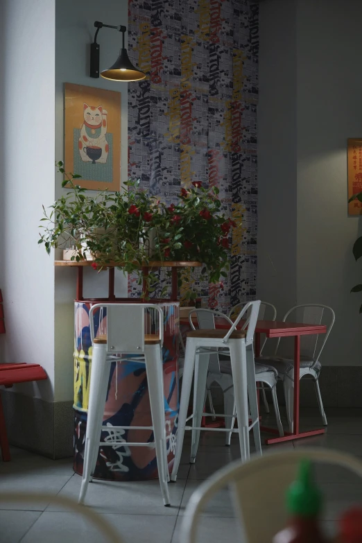 a room with multiple table chairs and a potted plant