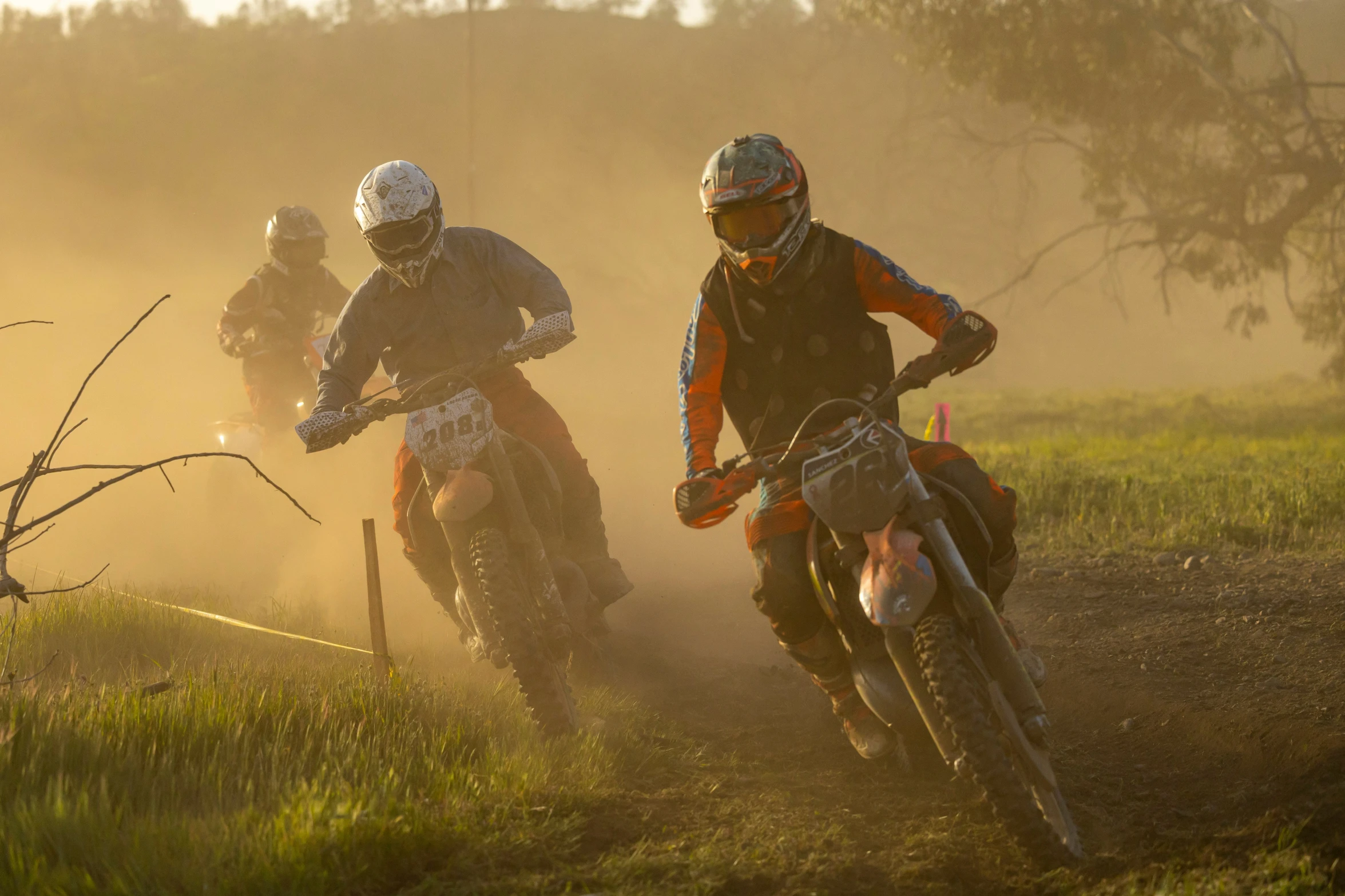 two motorcyclists race on a dirt track