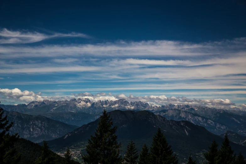 mountains and trees with clouds rolling in from the top