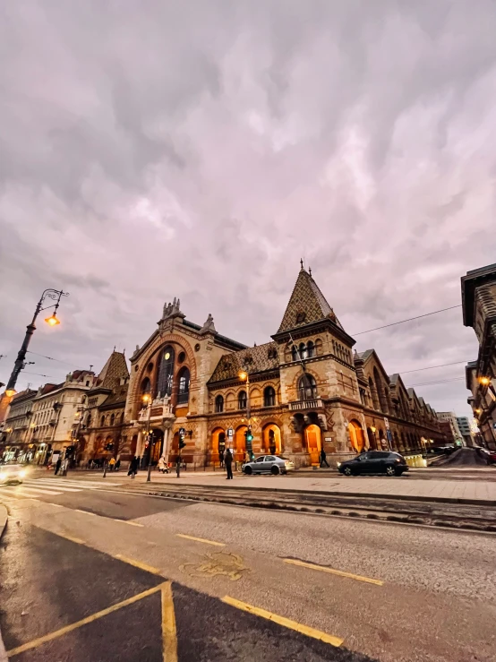 a large building on the corner of a road at dusk