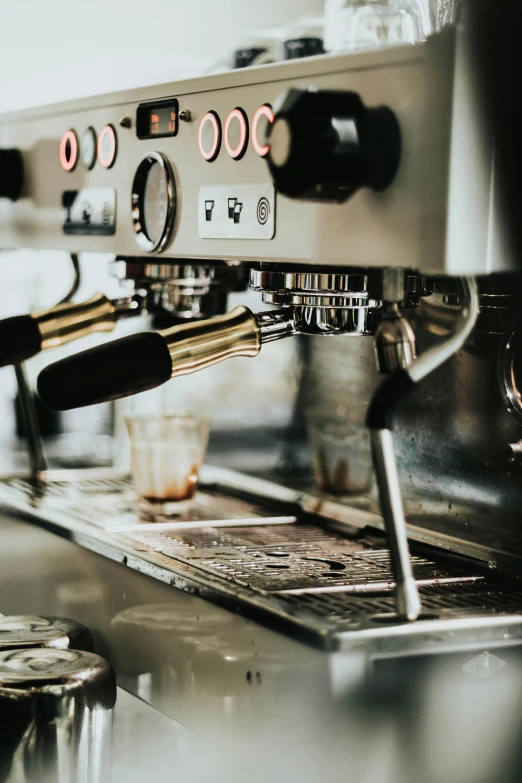 a close up of coffee being made in a commercial machine