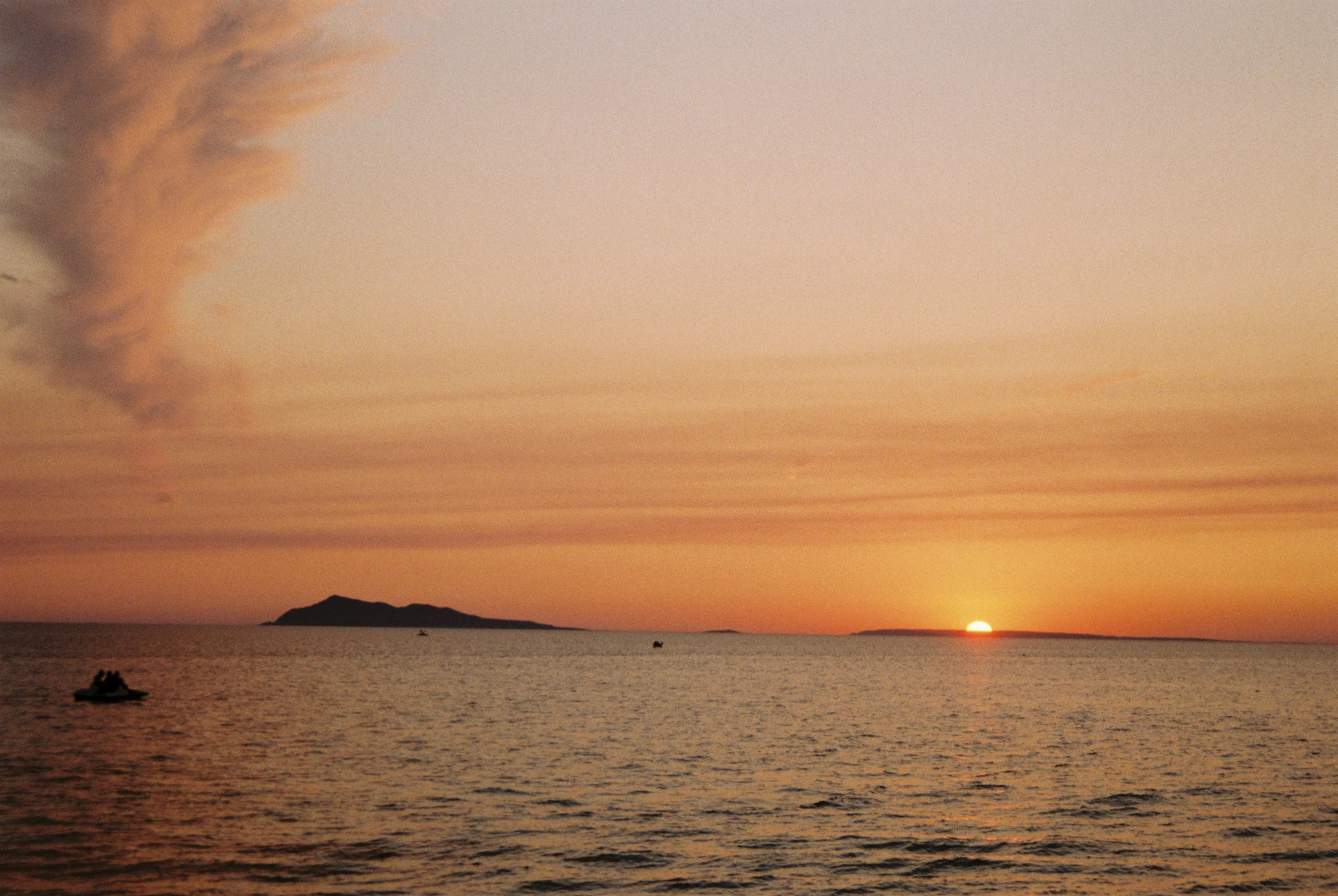 a beautiful sunset in front of some very small island