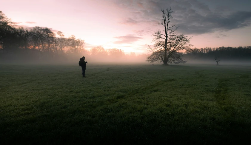 a person standing on top of a lush green field