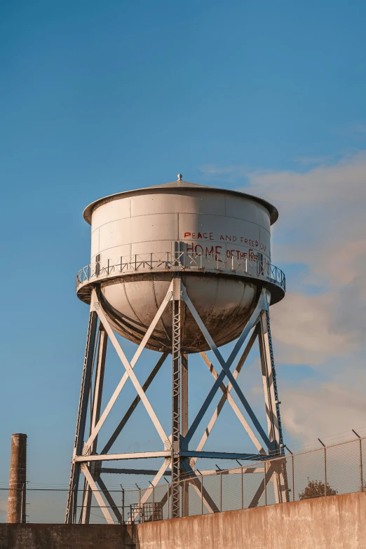 a large white water tower with the sky behind it