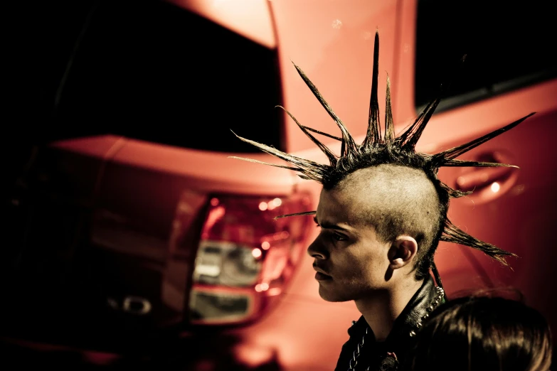 a young man with spiked hair is staring off in the distance