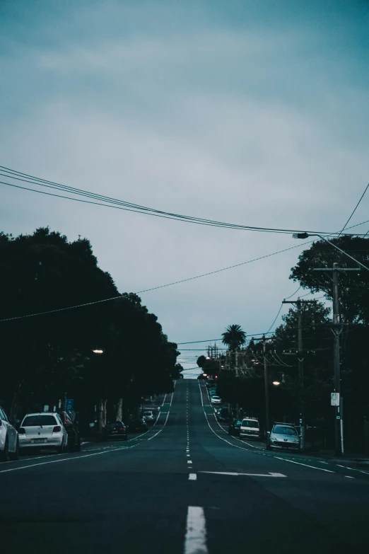 the road has several cars parked along the side