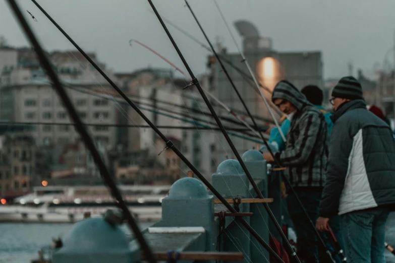 people fishing on a dock with buildings in the background