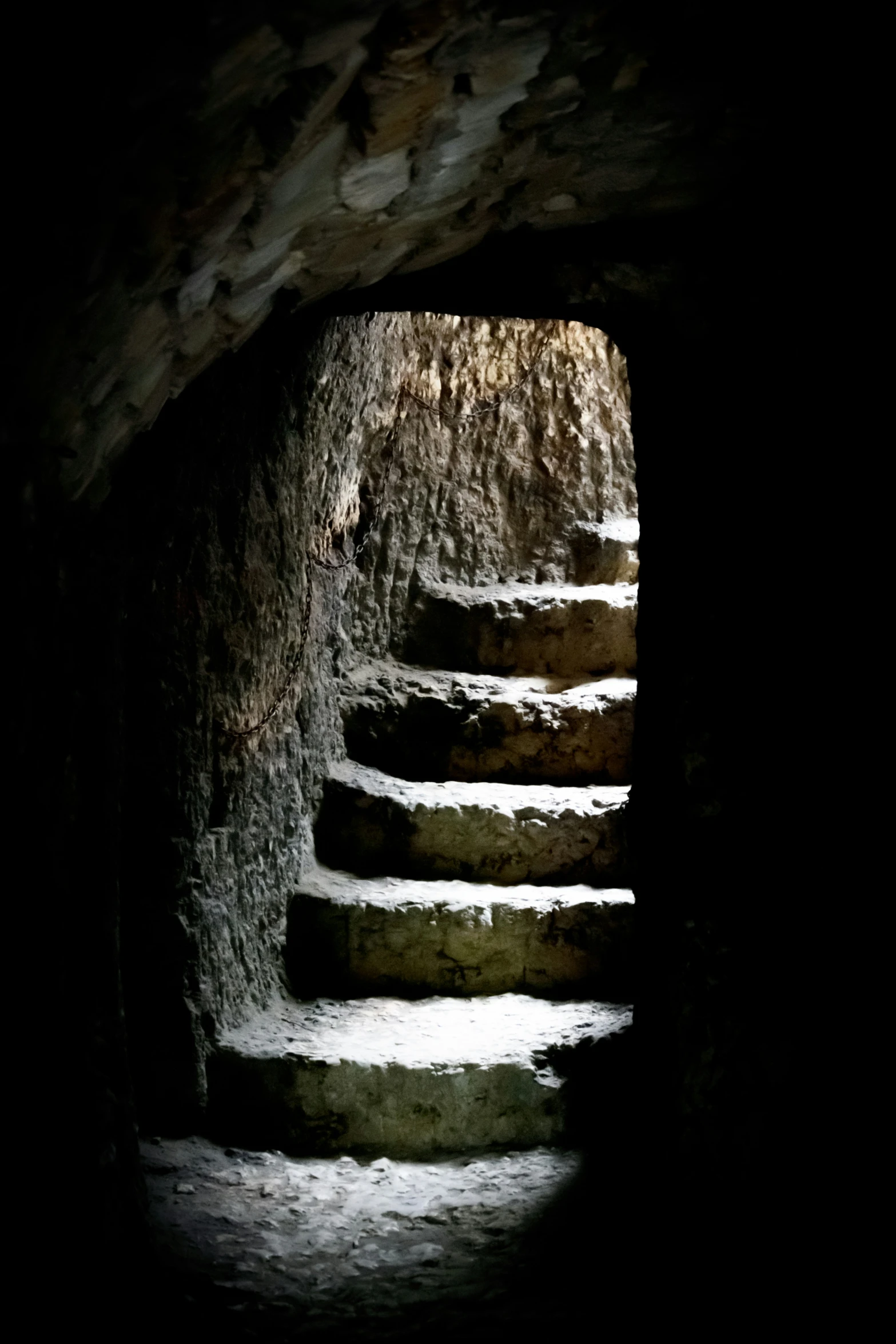 a group of steps going down into a dark tunnel