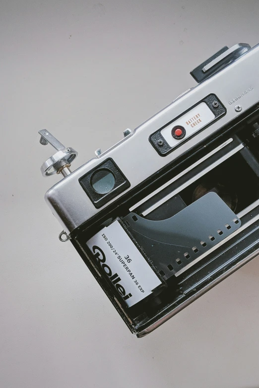 a silver camera with a black case and some stickers