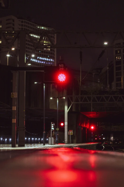 a red stop light on the road at night