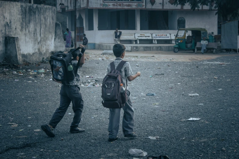 two people walking and taking pictures in a dirty street