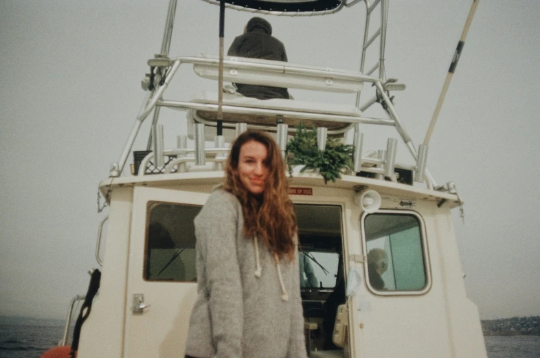 a man in grey sweater standing on front of boat