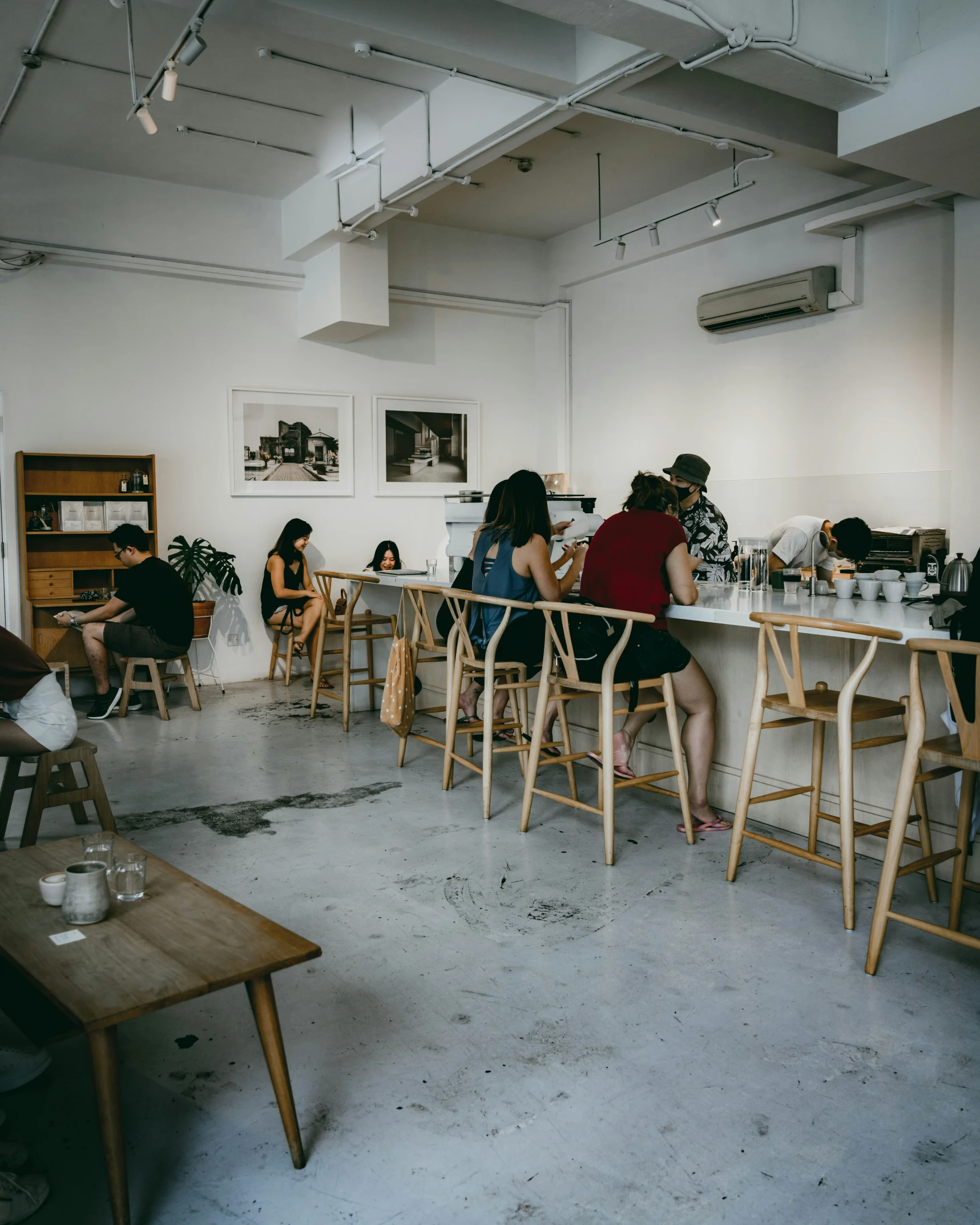 people sitting in wooden chairs at small tables