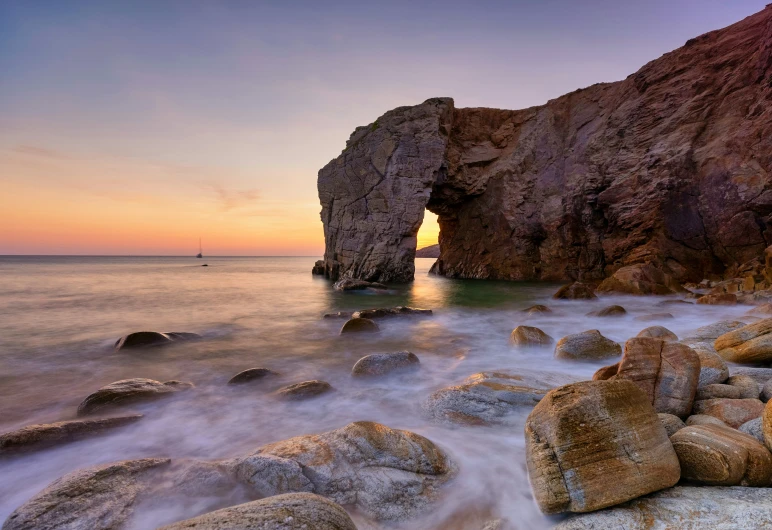 a rocky coast with water and rocks at sunset