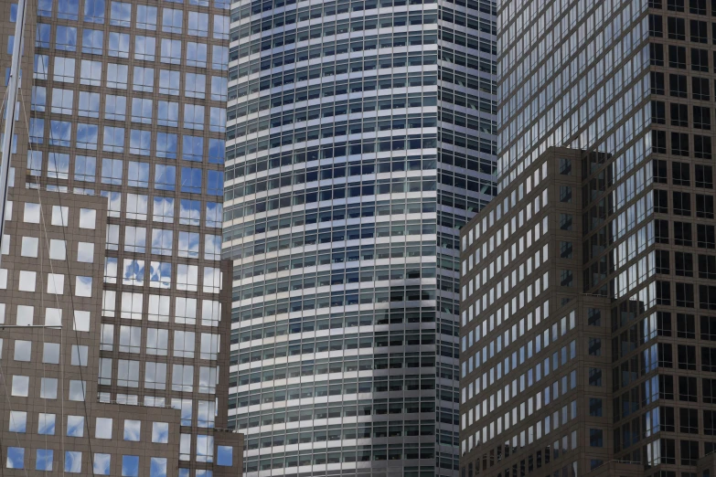 three tall buildings with a clock tower in the foreground