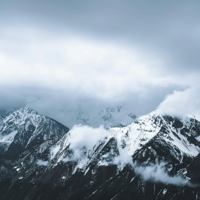 snow covered mountains under a cloudy sky