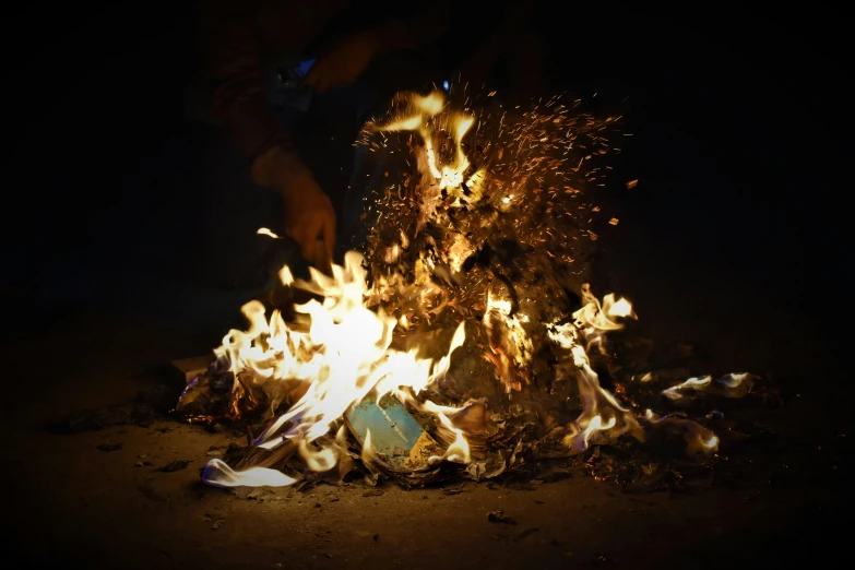 fire blazing in the dark on top of an open flame pit