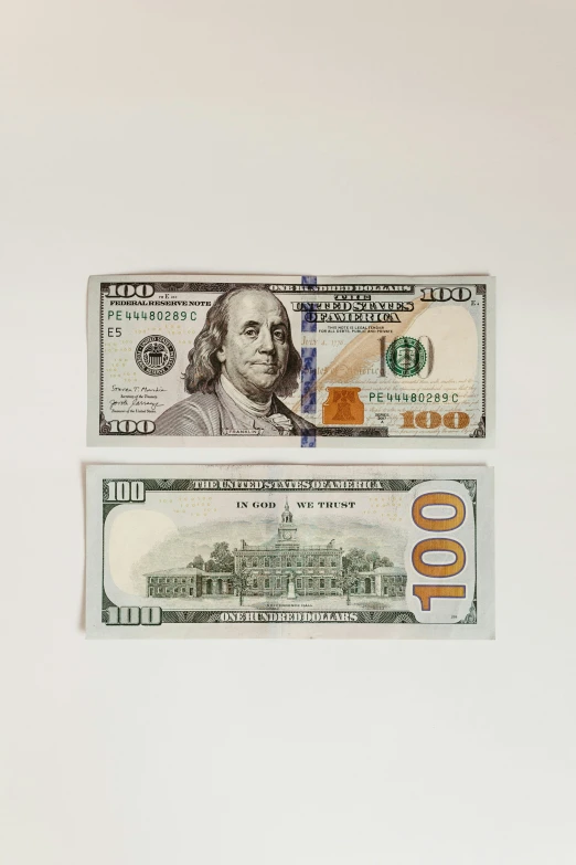 two one dollar bills side by side on white paper