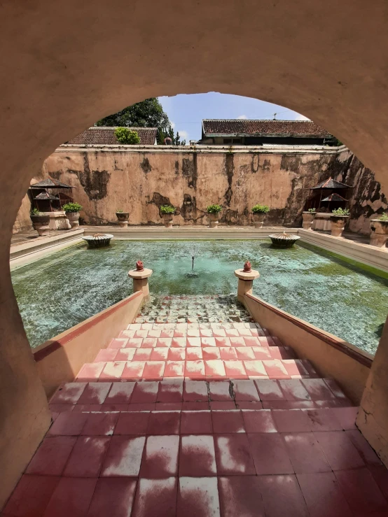 an archway in a courtyard with brick walls