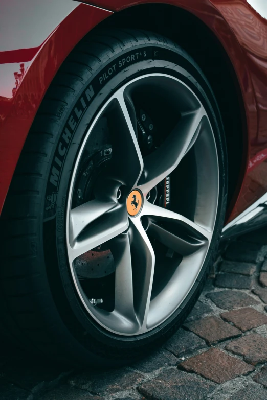 a close up of a red sports car wheel