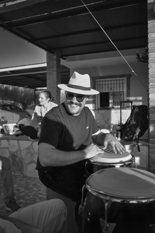 a man wearing sunglasses, a hat and a guitar