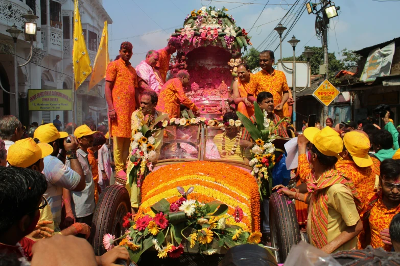 an elaborate decorated vehicle is among many people