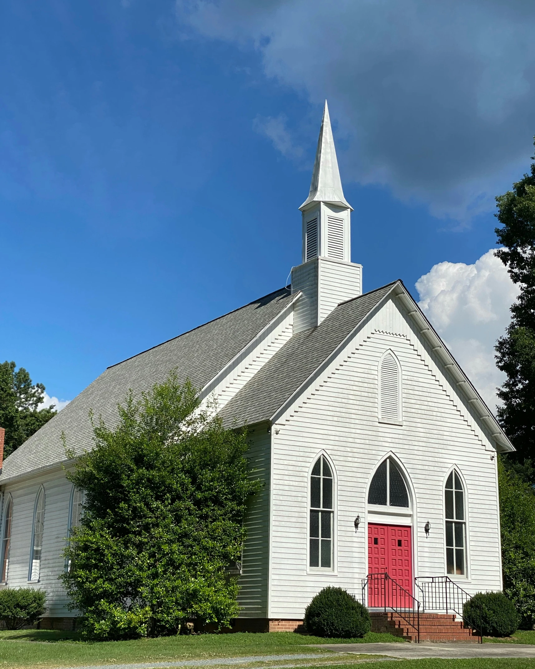 the small white church has a red door