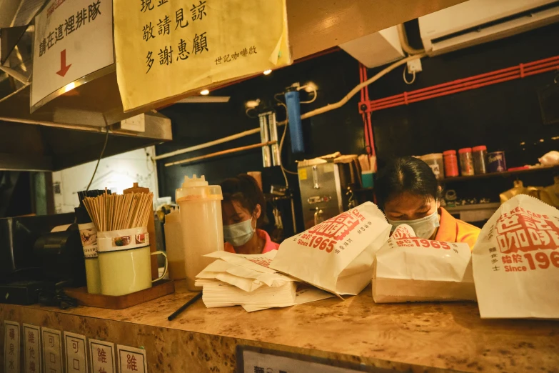 customers wearing masks sit in a fast food restaurant