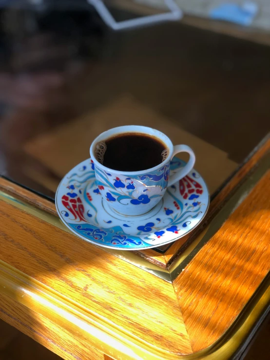 a cup of coffee sits on a colorful table