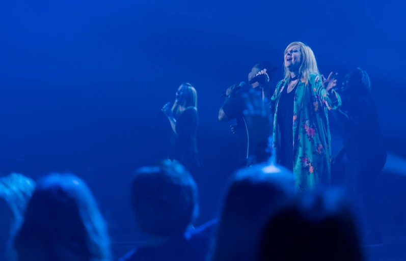 a woman that is on stage holding a microphone