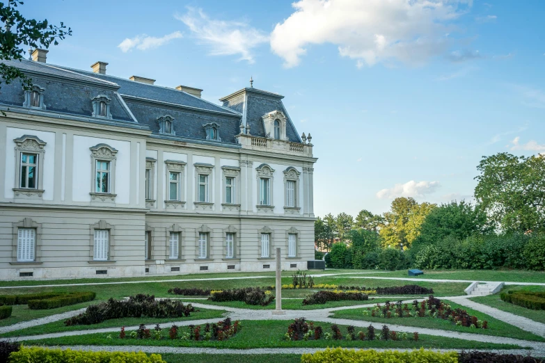 a big mansion with lots of plants around it