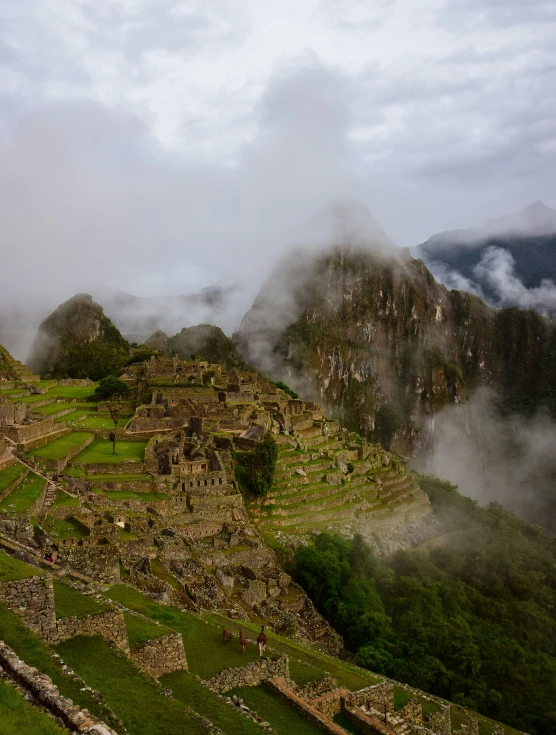 the ruins on the side of the mountain are surrounded by clouds