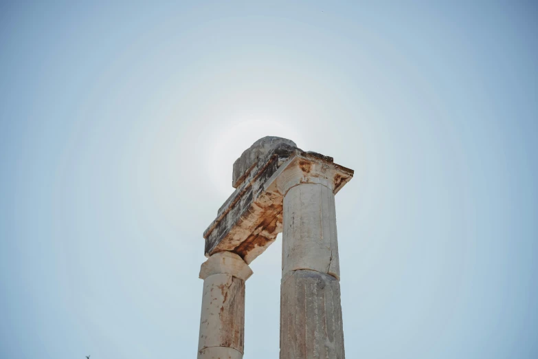 an ancient structure with sun light reflecting off the pillars