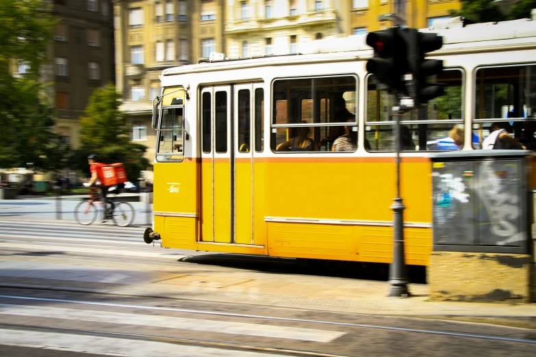 a yellow trolley on street next to buildings