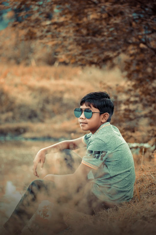 a  in shades sitting in the grass