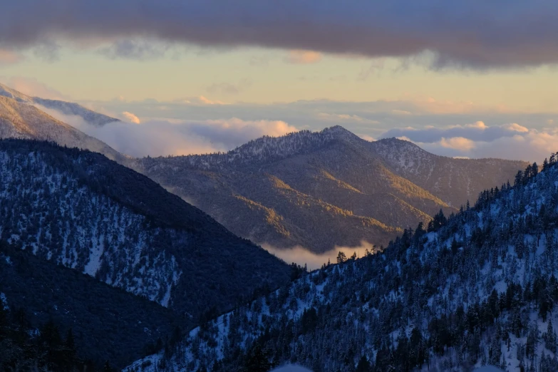 a group of mountains covered in snow and clouds