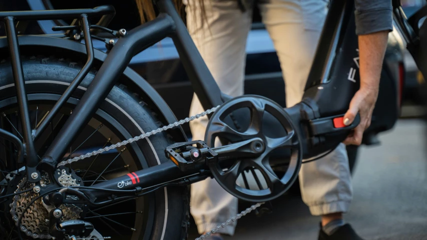 closeup of bicycle wheel, person's bike on the other side of car